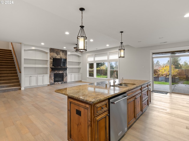 kitchen with dishwasher, plenty of natural light, hanging light fixtures, and a kitchen island with sink