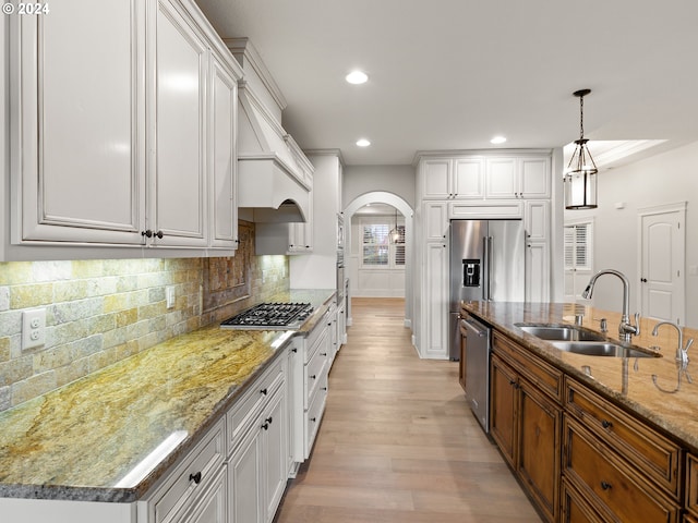 kitchen featuring white cabinets, sink, a center island with sink, and light hardwood / wood-style flooring