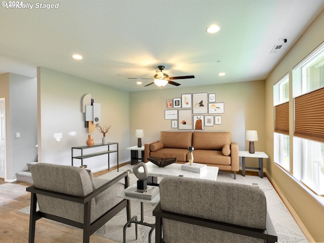 living room featuring ceiling fan and light hardwood / wood-style flooring