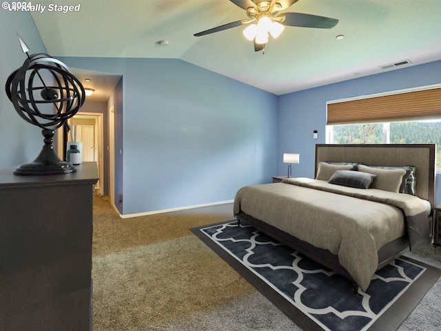 bedroom with dark colored carpet, lofted ceiling, and ceiling fan