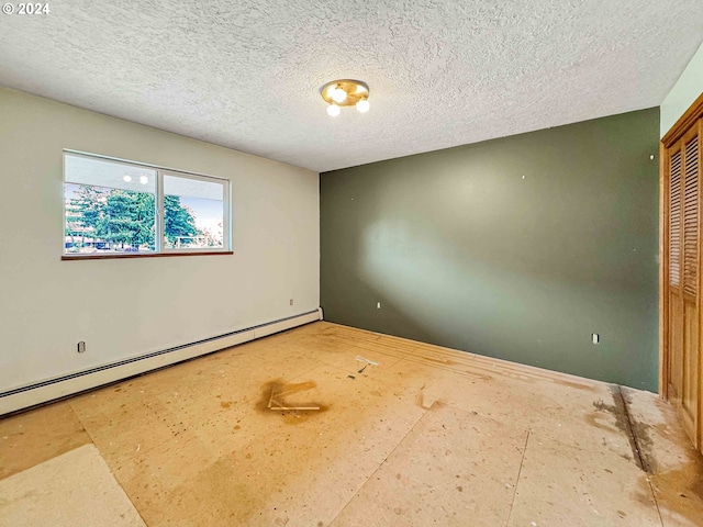 spare room featuring a baseboard heating unit and a textured ceiling