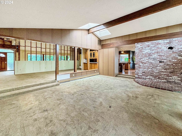 unfurnished living room featuring brick wall, carpet, and vaulted ceiling with skylight