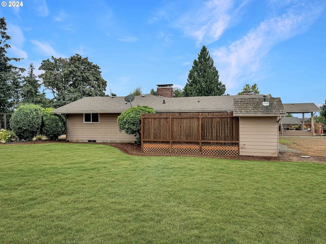 back of property featuring a lawn