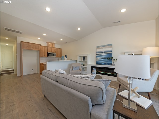 living room featuring vaulted ceiling and light hardwood / wood-style floors