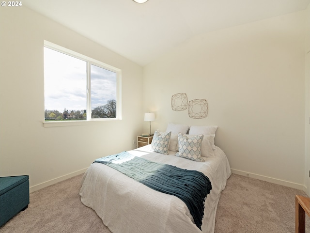 bedroom with vaulted ceiling and light carpet