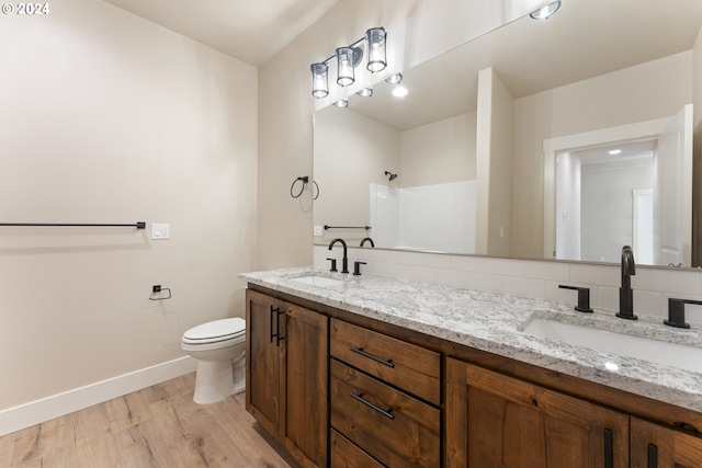 bathroom with a shower, toilet, vanity, and hardwood / wood-style flooring