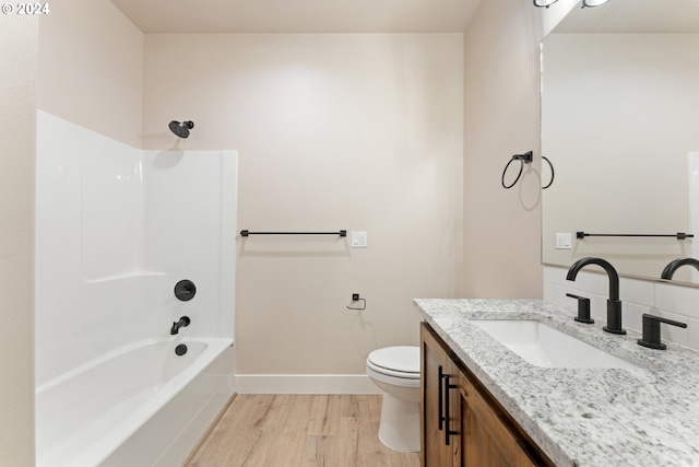 full bathroom featuring hardwood / wood-style floors, vanity, toilet, and tub / shower combination