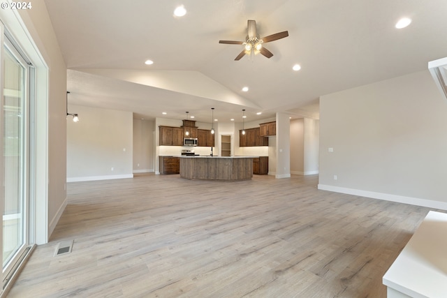 unfurnished living room featuring light hardwood / wood-style flooring, vaulted ceiling, and ceiling fan