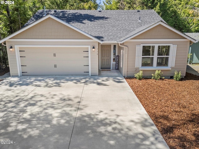 ranch-style house with a garage, roof with shingles, and driveway