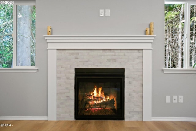 interior details featuring hardwood / wood-style flooring and a brick fireplace