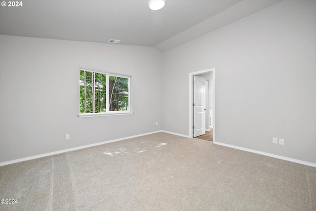 unfurnished room with lofted ceiling, baseboards, visible vents, and carpet floors