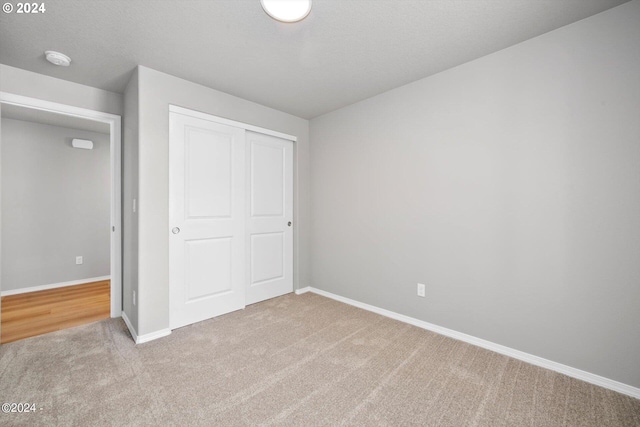 unfurnished bedroom featuring a closet, baseboards, and carpet