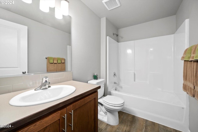 bathroom with tasteful backsplash, visible vents, toilet, wood finished floors, and vanity