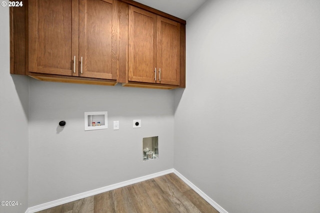 laundry room with electric dryer hookup, wood finished floors, cabinet space, baseboards, and hookup for a washing machine