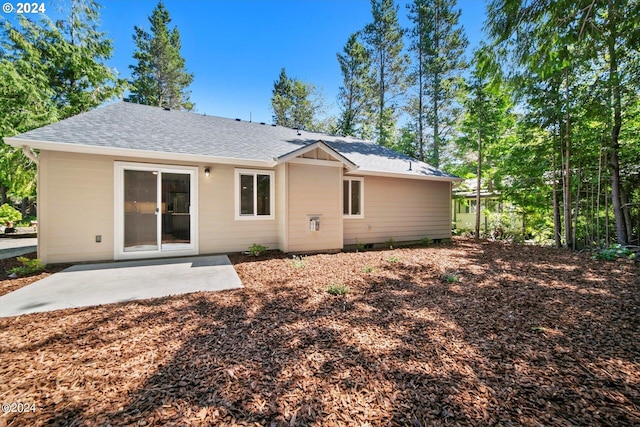 back of property featuring a patio and a shingled roof