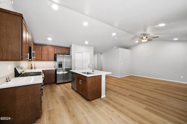 kitchen with a kitchen island with sink, stainless steel appliances, sink, ceiling fan, and light hardwood / wood-style floors