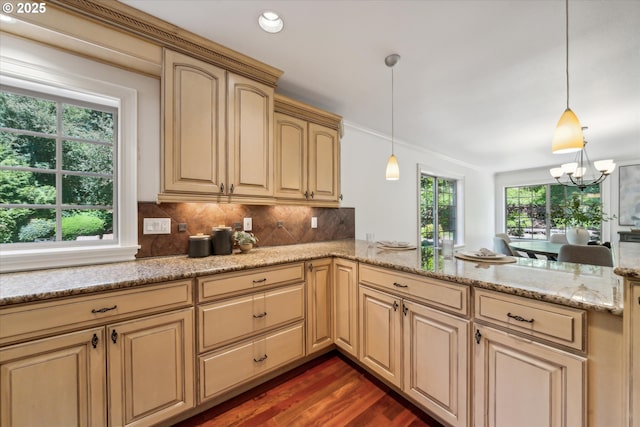 6145 SW Sweetbriar Ct, Portland, OR 97221 - kitchen featuring a peninsula, tasteful backsplash, dark wood-type flooring, pendant lighting, and a chandelier