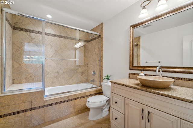 bathroom with visible vents, toilet, tiled shower / bath combo, vanity, and tile patterned flooring