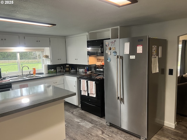 kitchen with sink, white cabinetry, wood-type flooring, black appliances, and a textured ceiling