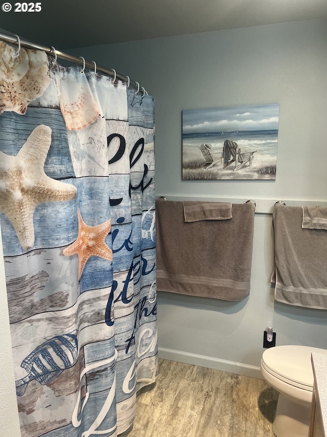 bathroom featuring a shower with curtain, wood-type flooring, and toilet