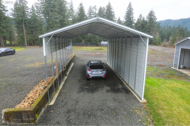 view of parking / parking lot with a carport and a mountain view