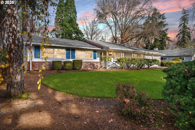 ranch-style home with a yard