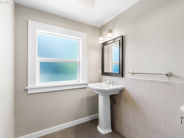 bathroom with tile patterned flooring, a healthy amount of sunlight, and tile walls