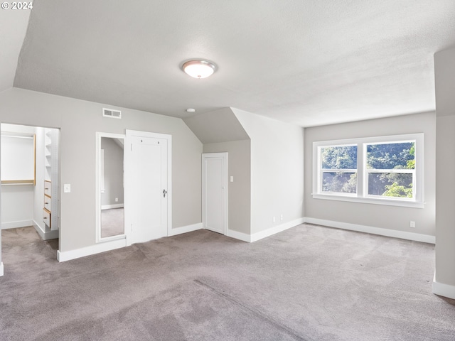 bonus room featuring lofted ceiling and light colored carpet