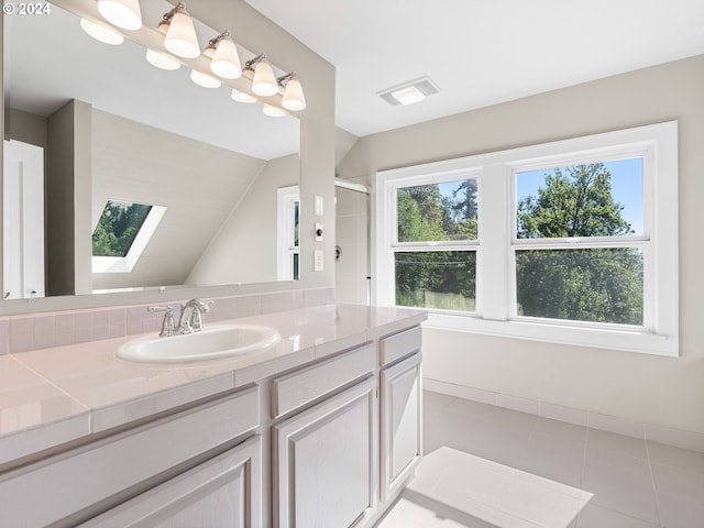 bathroom with walk in shower, vanity, tile patterned flooring, and lofted ceiling with skylight