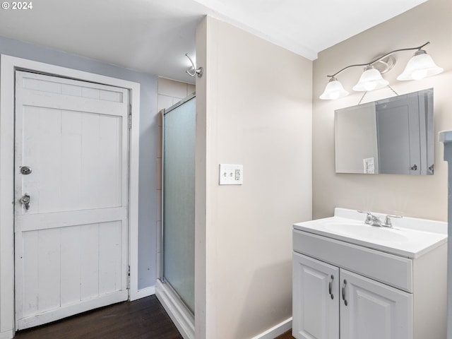 bathroom with a shower with shower door, hardwood / wood-style flooring, and vanity