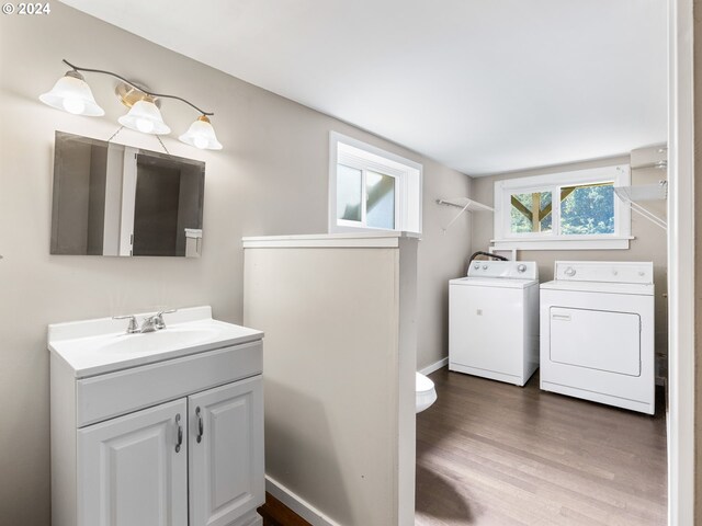 bathroom with washer and clothes dryer, vanity, and hardwood / wood-style flooring