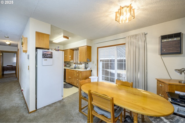 carpeted dining room with sink, a wall mounted air conditioner, and a textured ceiling