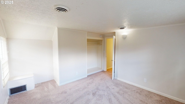 unfurnished room with light carpet and a textured ceiling