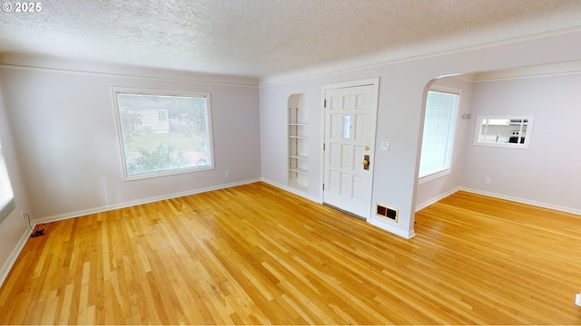 entryway with hardwood / wood-style flooring, a healthy amount of sunlight, and a textured ceiling