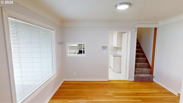 clothes washing area with hardwood / wood-style floors and a textured ceiling