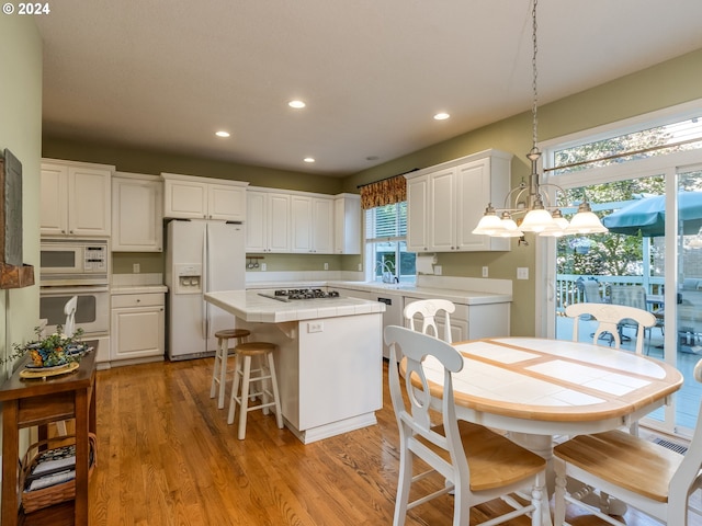 15337 SE Olds Dr, Clackamas, OR 97015 - kitchen featuring white appliances, tile countertops, white cabinets, recessed lighting, and a kitchen island