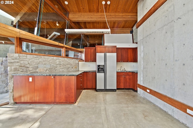 kitchen featuring white refrigerator with ice dispenser, beamed ceiling, and sink