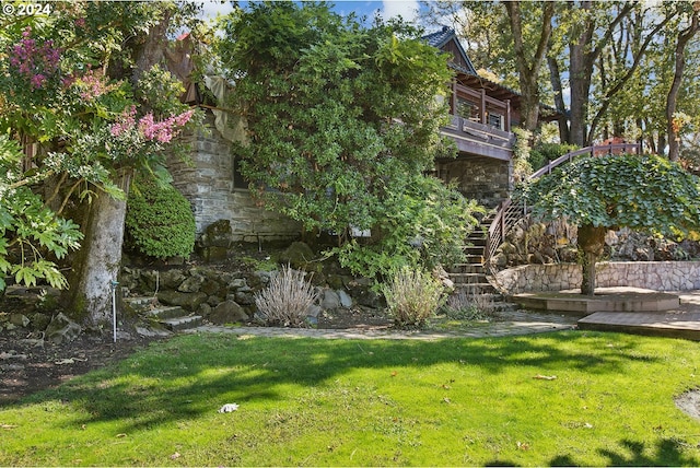 view of yard featuring a balcony and stairs