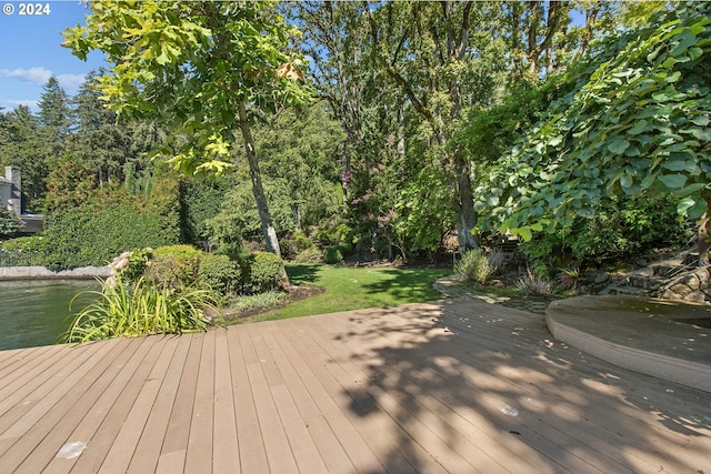 wooden deck featuring a lawn