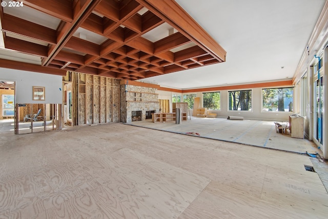 misc room featuring a stone fireplace, coffered ceiling, and visible vents