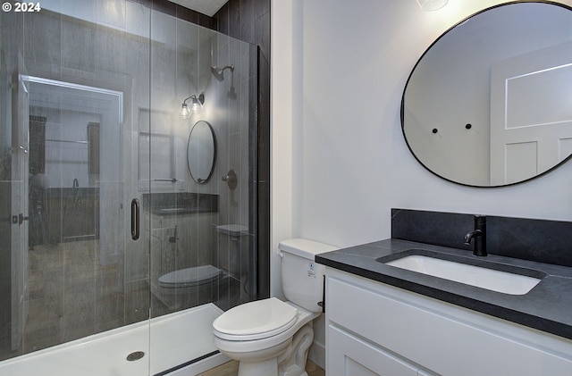 bathroom featuring vanity, toilet, and an enclosed shower