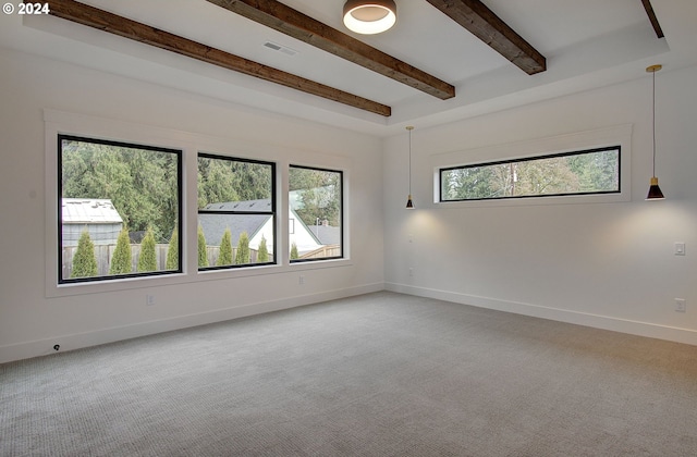 empty room featuring carpet flooring and beamed ceiling