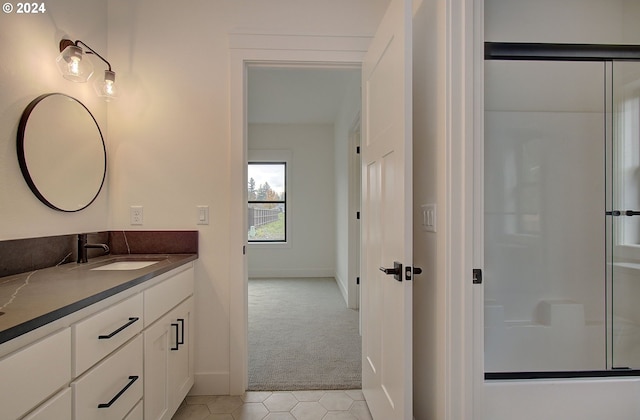 bathroom featuring tile patterned flooring, vanity, and a shower with door