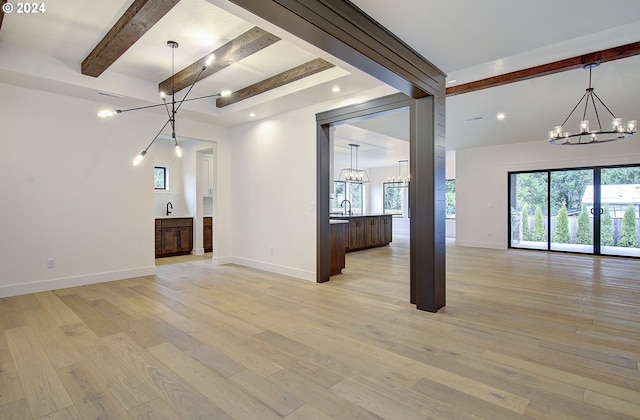 unfurnished living room with beam ceiling and light wood-type flooring