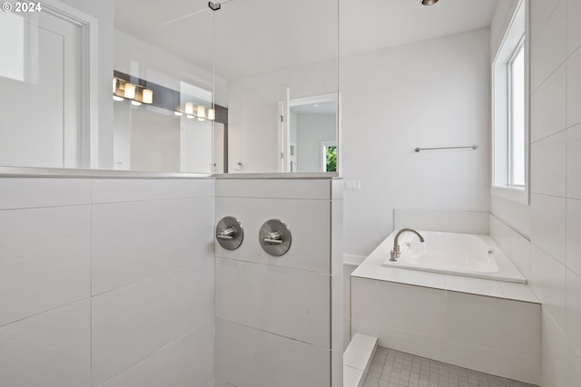 bathroom with shower with separate bathtub and tile patterned floors