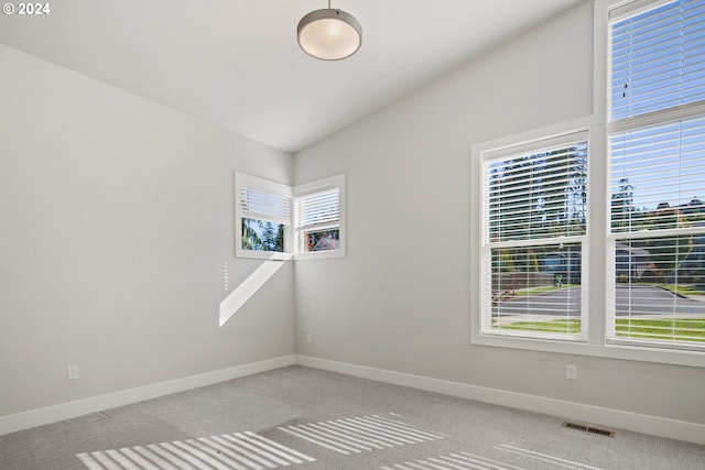 carpeted spare room featuring lofted ceiling