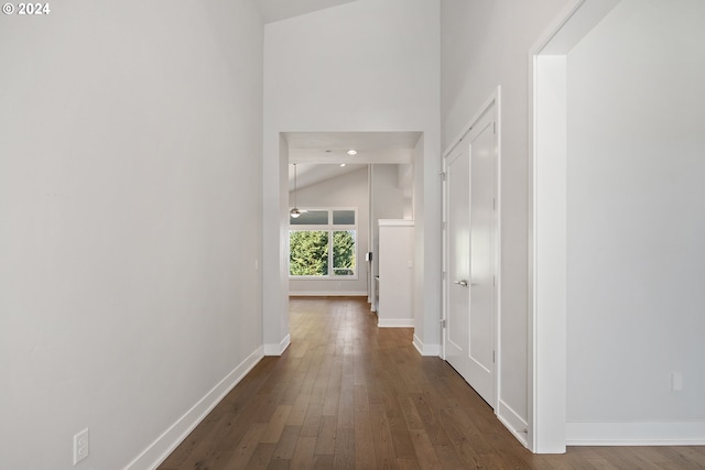 hallway featuring dark hardwood / wood-style flooring and high vaulted ceiling