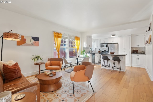 living room with baseboard heating and light wood-type flooring