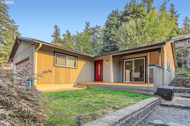 view of front of property with a wooden deck, a garage, and a front yard