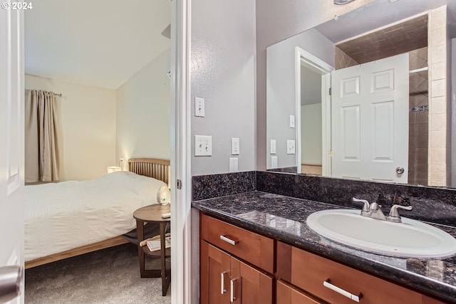 bathroom featuring a tile shower and vanity